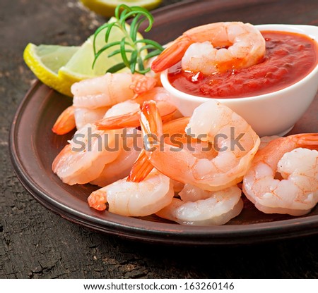 tails of shrimps with fresh lemon and rosemary in a ceramic plate