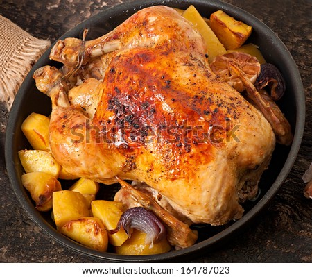 Baked whole chicken with potatoes, garlic and onion