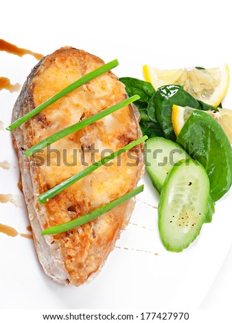 Fish dish - fried fish fillet with vegetables on white background