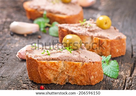Homemade meat snack chicken liver pate with savory and olives