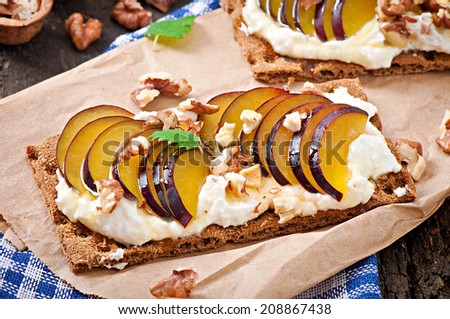 Vegetarian Diet sandwiches Crispbread with cottage cheese, plums, nuts and honey on old wooden background