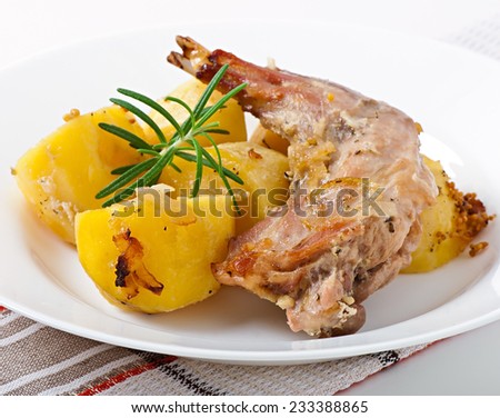 Oven Baked rabbit legs with potatoes and rosemary