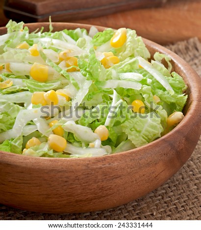 Chinese cabbage salad with sweet corn in a wooden bowl