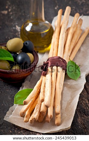 Grissini bread sticks on old wooden background