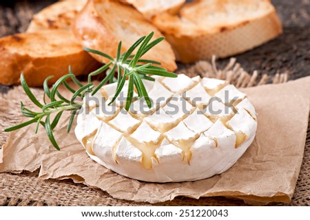 Baked Camembert cheese with rosemary and toast rubbed with garlic