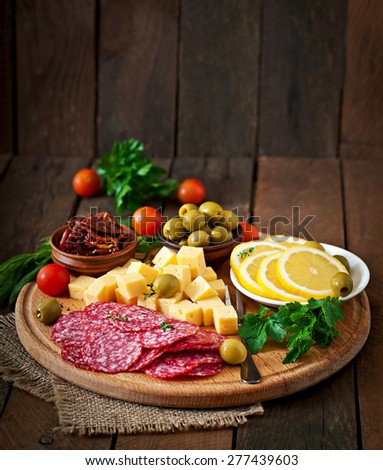Antipasto catering platter with salami and cheese on a wooden background