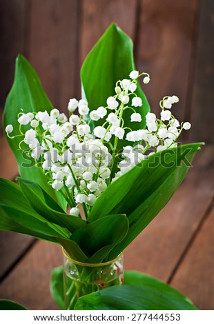 Beautiful wood lilies of the valley on a wooden table