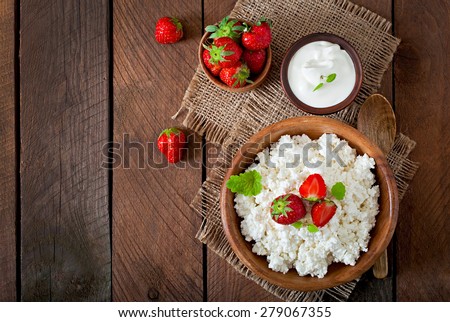 Cottage cheese with strawberries in a wooden bowl.  Top view