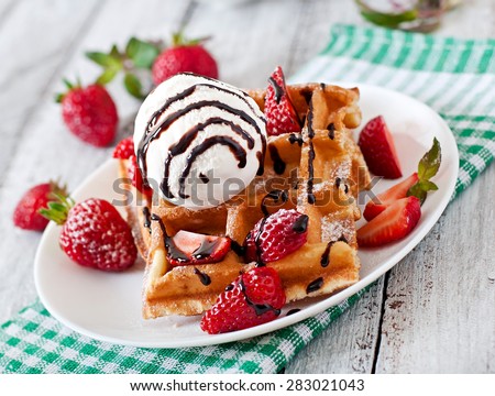 Belgium waffles with strawberries and ice cream on white plate