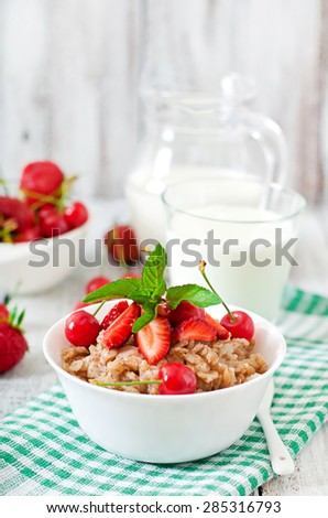 Oatmeal porridge with berries in a white bowl