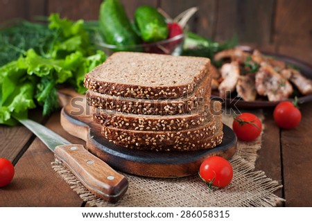 Wholegrain rye bread with bran and seeds on  wooden table, healthy eating