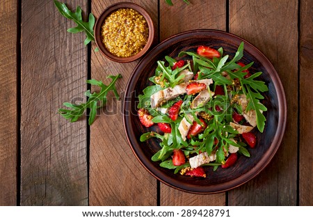 Chicken salad with arugula and strawberries. Top view