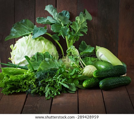Useful green vegetables on a wooden background