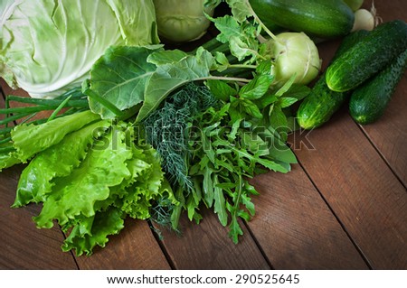 Useful green vegetables on a wooden background