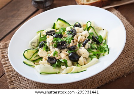 Zucchini salad with feta, olives and pine nuts