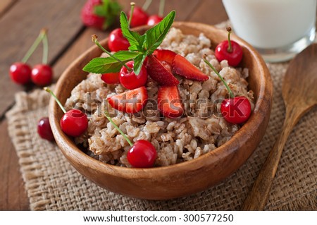 Oatmeal porridge with berries in a wooden bowl