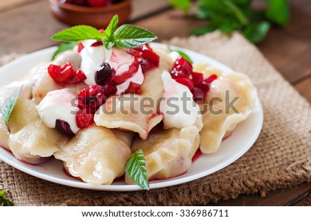 Delicious dumplings with cherries, sour cream and jam