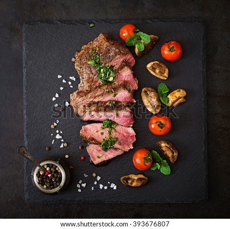 Juicy steak medium rare beef with spices and grilled vegetables. Top view
