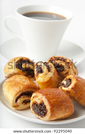 Cup of coffee and small rolls with a poppy