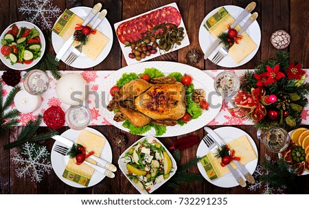 Baked turkey. The Christmas table is served with a turkey, decorated with bright tinsel and candles. Fried chicken, table. Christmas dinner. Flat lay. Top view