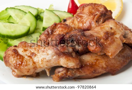 Grilled chicken on a white plate with vegetables on the background. - stock photo