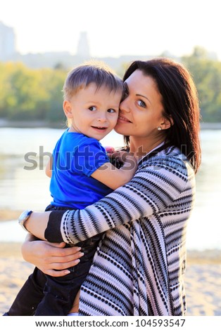 Young woman and at her son during a walk at the beach