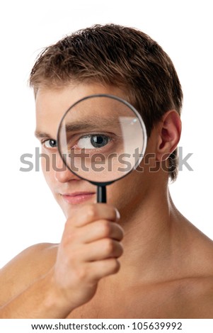Cute young man without a shirt looking through a magnifying glass