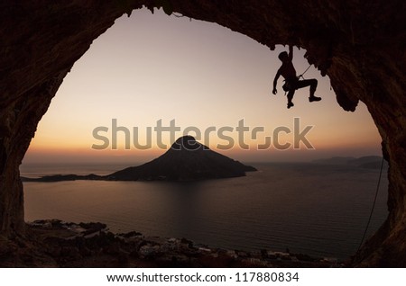 Silhouette of a rock climber against view of Telendos Island at sunset. Kalymnos Island, Greece.
