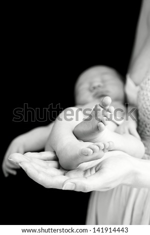 Young caucasian woman holding newborn son, shallow depth of field