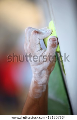 Closeup of man\'s hand on handhold on artificial climbing wall, hand in focus