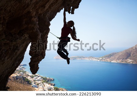 Silhouette of a young female rock climber on a cliff. Kalymnos Island, Greece