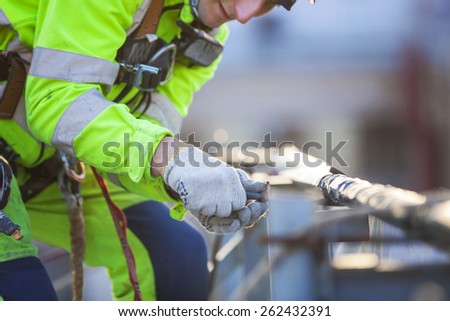Closeup of industrial climber working on roof of building