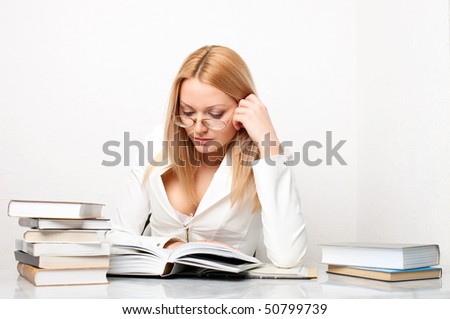 Young pretty woman learning at table with a lot of books, educational concept