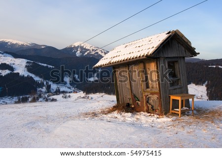 Winter landscape with a wooden watch-box next to the alpine skiing track in the mountains