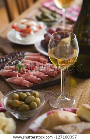 Glass of white wine on a table full with food