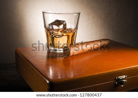 Whiskey and cigar on wooden box close up