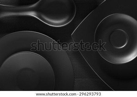 Top view of black empty plates on dark grey background