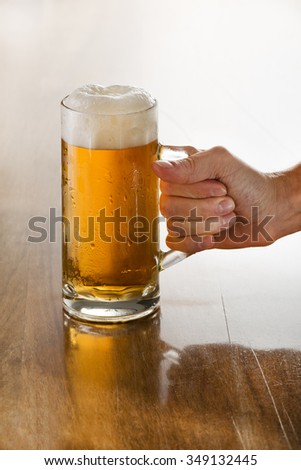 Bartender holding a freshly tapped glass of beer in his hand.