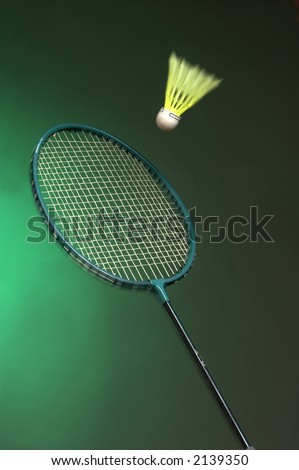 badminton racket and shuttle on green background close up