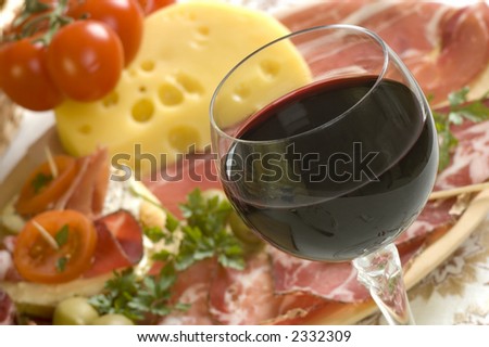 glass of red wine close up with food in background