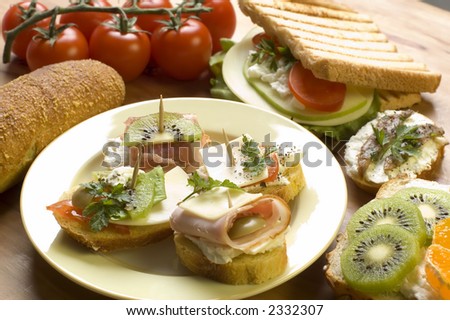arranged snack made of small sandwiches, toast, fruit , potato