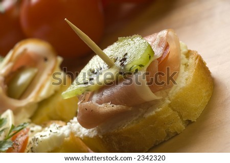 small snack with prosciutto cheese and olive close up