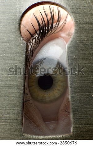 One eye looking through a keyhole close up shoot