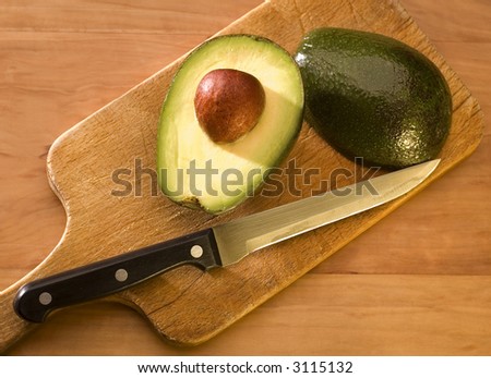 Avocado fruit halves on a chopping board