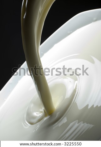 white milk pouring from bottle into a bowl