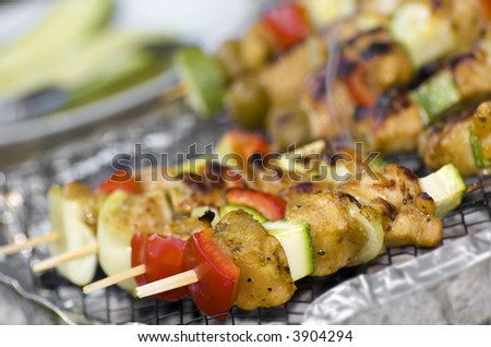 chicken meat with vegetables on stick grilled on barbecue close up