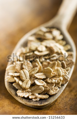 muesli flakes in a wooden spoon close up