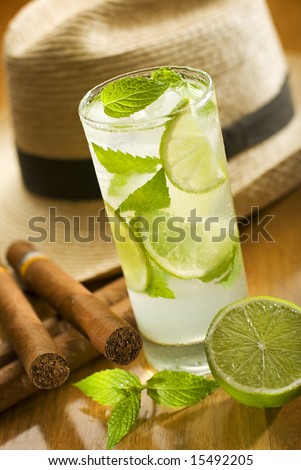 fresh mojito with cuban cigars and hat in background