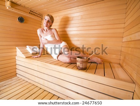 young blond woman sitting in sauna - health
