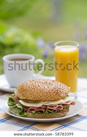 Fresh prosciutto sandwich with coffee and juice close up